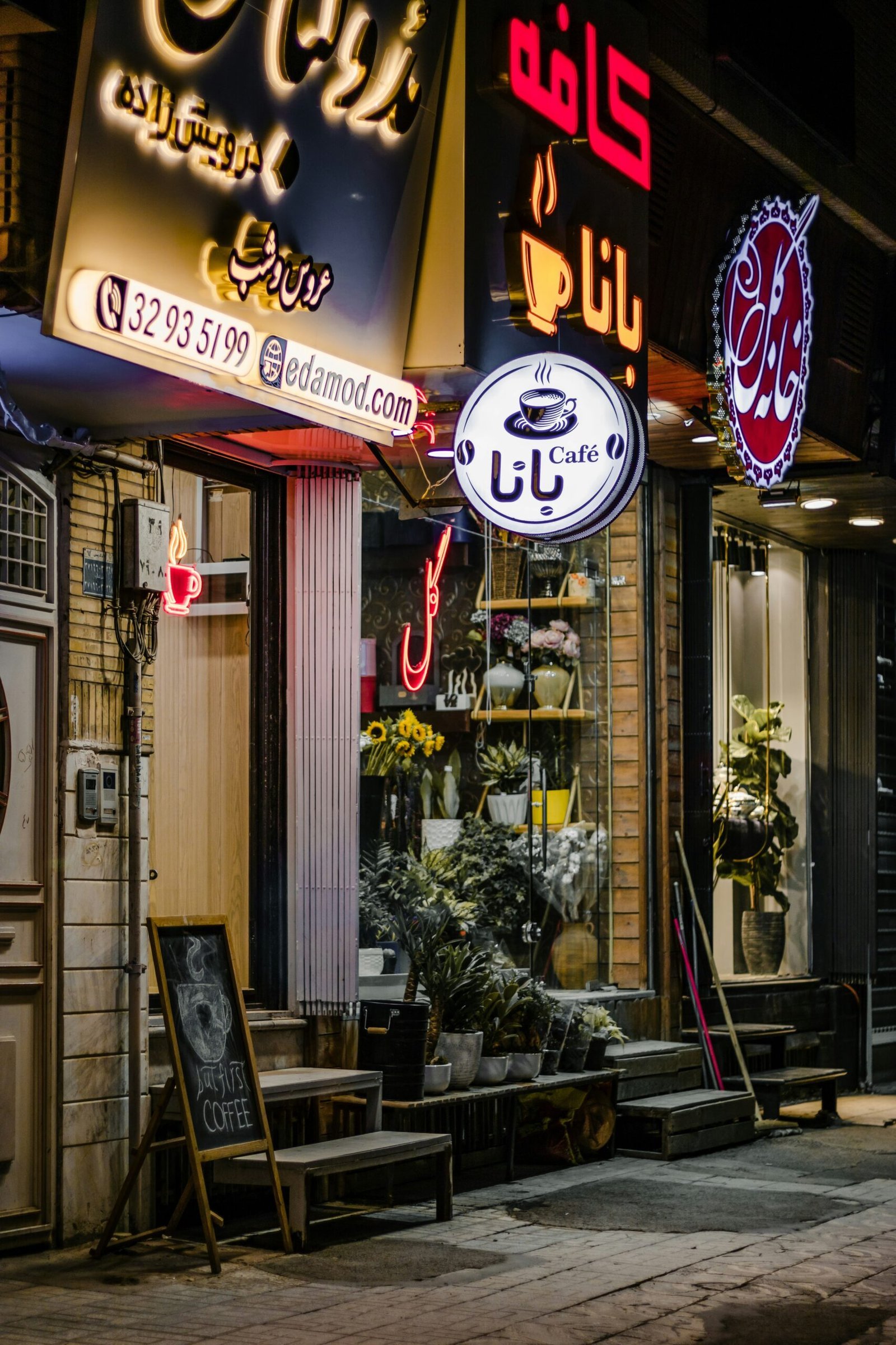 A store front with many signs lit up at night